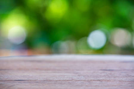Empty curved wooden table texture, Green garden blurred bokeh background, Selective focusの写真素材