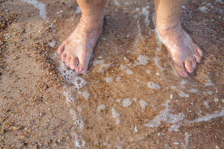 Senior woman's feet are standing on sandy beach, Varicose veins on leg and feet, Asian Body skin part, Healthcare conceptの写真素材