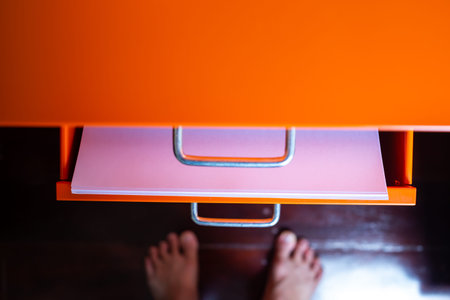 Filing cabinet with open drawer, White papers  for write letter, Orange metal colour, Administration and storage concept, closeup & Macro shot, Selective focusの写真素材