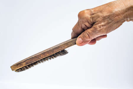Senior Woman's right hand holding old wire brush isolated on white background, Construction building and repair tool conceptの写真素材