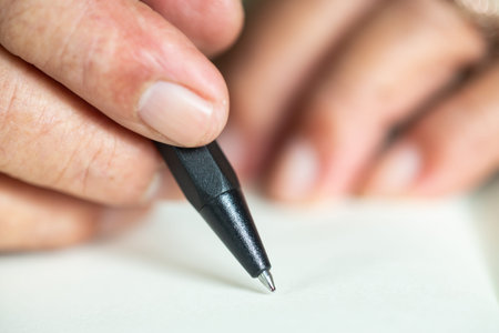 Senior man's hand writing letter on ivory color paper, Notebook,  A black pen, Close up & Macro...