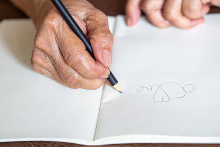 Senior woman's right Hand  writing letter "LOVE"の写真素材