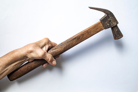 Senior Woman's left hand holding hammer on white background, Construction building and repair tool...