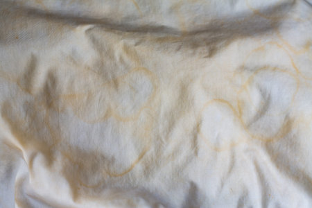 Dirty stained pillow on new white bed, Close up and macro shot, Selective focus, Bedroom cleaning conceptの写真素材