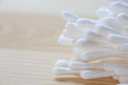 White plastic cotton buds on wood table texture background, Close up & Macro shot, Selective focus,...