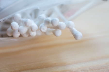 White plastic cotton buds on wood table texture background, Close up & Macro shot, Selective focus, About Cleaning Body, Healthcare conceptの写真素材