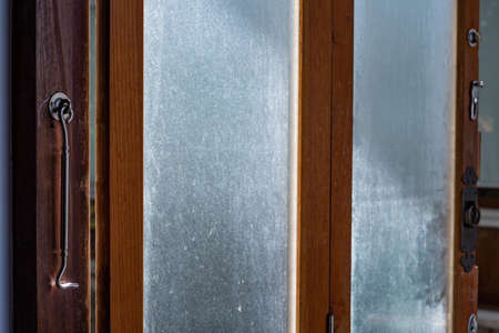 Aluminium Latch  is connected to ajar frosted Glass and wooden door  frame, Close up & Macro shot, Selective focus, Home conceptの写真素材