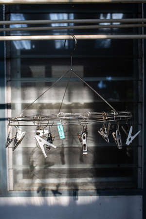 Stainless steel and plastic circle clothespin, Dusty mirror Window background, Light & Shadow, Laundry work conceptの写真素材
