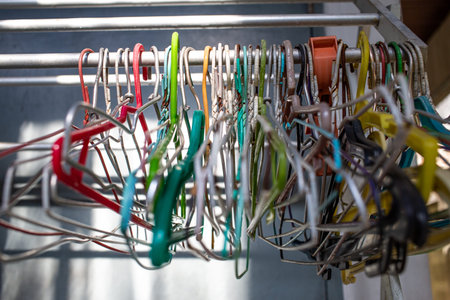 Old colorful plastic and steel  clothes hangers on clothes rack, Close up shot, Selective focus,...