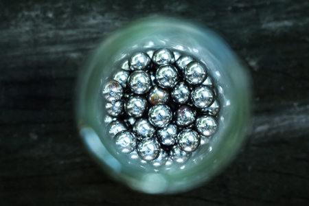 Blurred Metal sphere or steel balls in the bottle on wood texture background
