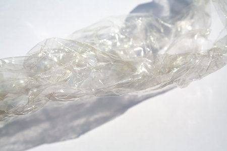 Abstract crumpled transparent plastic bag texture on white background, Close up & Macro shot, Selective focus, Light & Shadow, Recycle conceptの写真素材