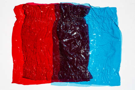 Thin sheet of multi coloured cellophane with shiny crumpled surface texture on white background, Abstract, Light & Shadow conceptの写真素材
