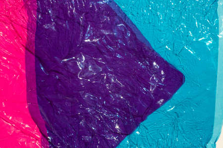 Thin sheet of multi coloured cellophane with shiny crumpled surface texture,  Abstract background, Light & Shadow conceptの写真素材