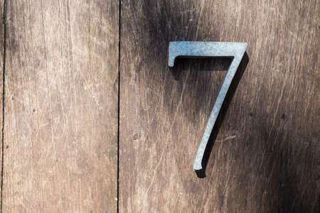 Number 7 (seven) made  from galvanized iron on wood texture backgroundの写真素材
