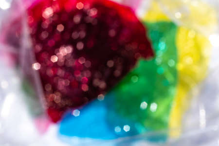Blurred bokeh thin sheet of multi coloured cellophane with shiny crumpled surface texture, Abstract, White background, Light & Shadow conceptの写真素材