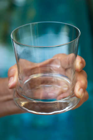 Asian Senior woman's hand drinking empty glass of clean water, Close up & Macro shot, Selective focus, Healthy Drink conceptの写真素材