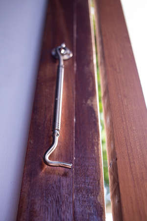 Aluminium Latch  is connected to ajar frosted Glass and wooden door  frame, Close up & Macro shot, Selective focus, Home conceptの写真素材
