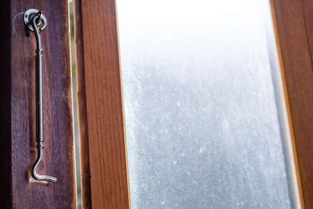Aluminium Latch  is connected to ajar frosted Glass and wooden door  frame, Close up & Macro shot, Selective focus, Home conceptの写真素材