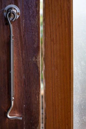 Aluminium Latch  is connected to ajar frosted Glass and wooden door  frame, Close up & Macro shot, Selective focus, Home conceptの写真素材