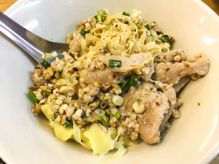 Pork dry noodles with minced pork, Pork wonton in white bowl on wooden table, Close up & Macro shot, Selective focusの写真素材
