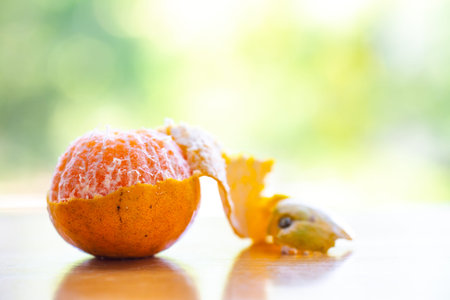 Orange fruit peeled on wooden table in the garden background, Close up shot, Selective focusの写真素材