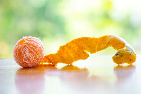 Orange fruit peeled on wooden table in the garden background, Close up shot, Selective focusの写真素材