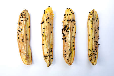 4 Baked Cultivated Bananas with black sesame seeds, Sesamum indicum isolated on white background, Close up & Macro shot, Healthy food conceptの写真素材