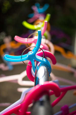 Colorful clothes Hangers and Clothes pegs  hanged on metal rack outdoor, Close upの写真素材