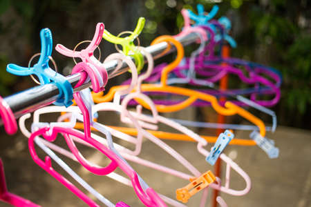 Colorful clothes Hangers and Clothes pegs  hanged on metal rack outdoor, Close upの写真素材