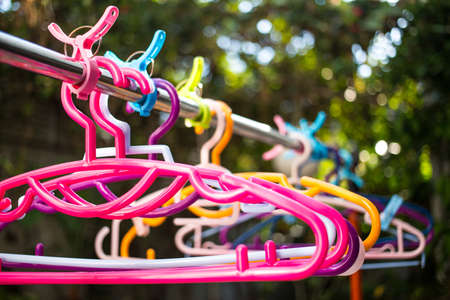 Colorful clothes Hangers and Clothes pegs  hanged on metal rack outdoor, Close upの写真素材