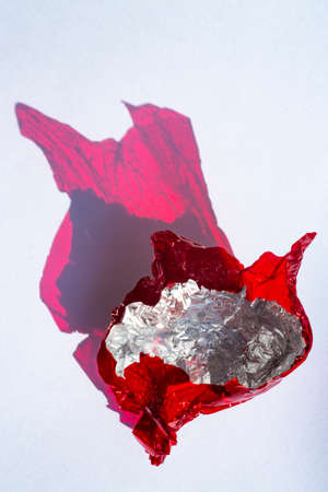 Thin sheet of red colour cellophane and Silver foil  with shiny crumpled surface texture  on white background, Abstract, Light & Shadow conceptの写真素材