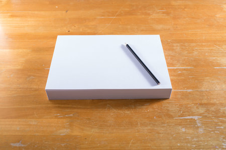 White paper with black pencil  on wood table