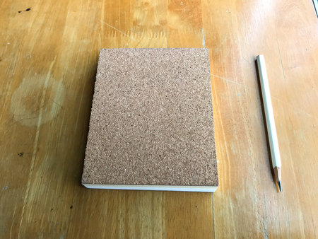 Notebook made by cork  with white pencil on wood background, Close up