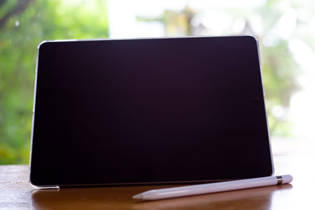 Bangkok Thailand - July 15, 2019 : Blurred Apple pencil with Black tablet computers iPad Pro on wood...
