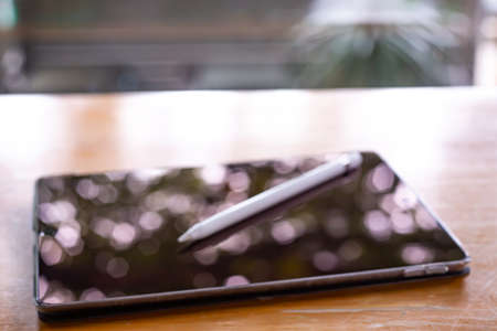 Bangkok Thailand - July 15, 2019 : Blurred Apple pencil with Black tablet computers iPad Pro on wood table, Technology, Business concept, iPad Pro 10.5 inch was created and developed by the Apple inc.のeditorial素材