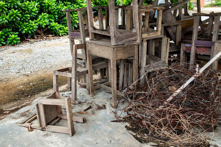 Abandoned broken vintage wooden chairs and vintage wooden desks in old schoolの写真素材