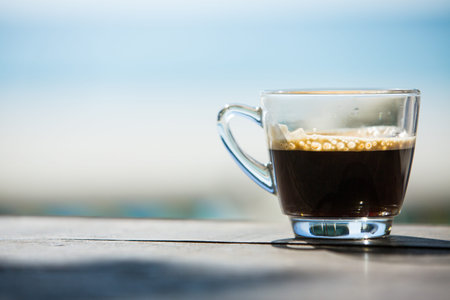 Coffee cup on wood table with sea and sand backgroundの写真素材