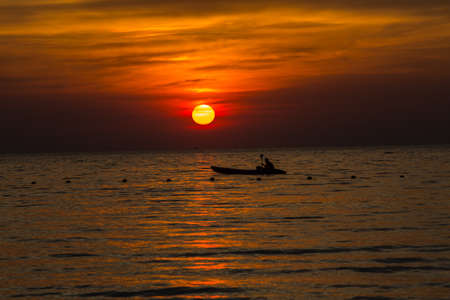 Sunset above the sea, Silhouette boatの写真素材