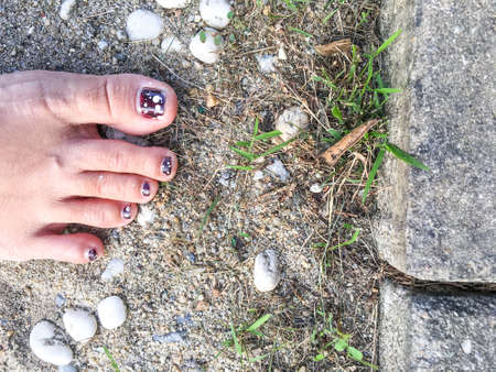 Womanâs carmine Nail with white polka dot on sandy Backgroundの写真素材
