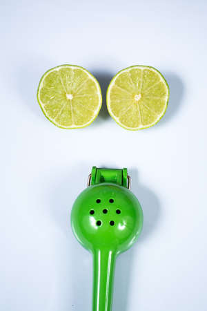 Lemon squeezer and a lime sliced in half isolated on white backgroundの写真素材