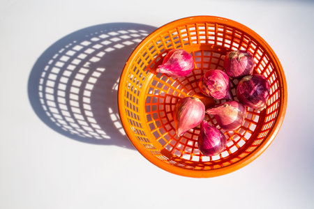Red onions in orange plastic basket isolated on white background, Top viewの写真素材