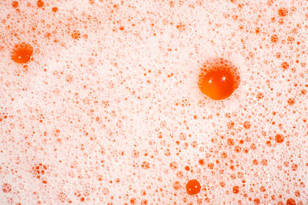Bubble Soapsuds transparent foam with water on orange background, Close up & Macro shot, Selective focusの写真素材