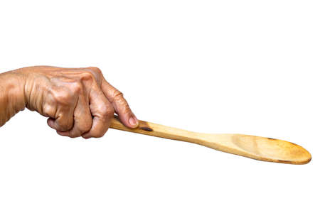 Senior woman's right hand holding wooden ladle on white background, Close up shot, Selective focus, Kitchen utensils conceptの写真素材