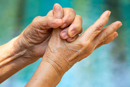 Senior woman's hands washing her hands in step 5 on bokeh blue pool  background, Close up & Macro shot, Selective focus, Prevention from covid19, Bacteria, healthcare concept, 7 step wash handの写真素材