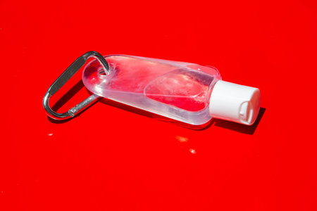 People's hands using wash hand sanitizer gel pump dispenser, Alcohol gel sanitizer on red, Close...
