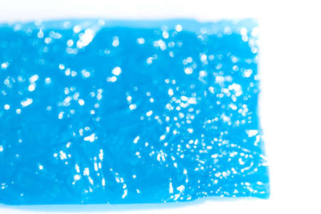 Bokeh blurred thin sheet of blue colour cellophane with shiny crumpled surface texture on white background, Abstract, Light & Shadow conceptの写真素材