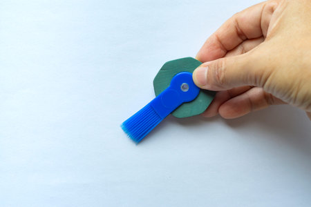 Woman's right hand holding vintage pen round rubber eraser with brush, Close up shot, Stationery...