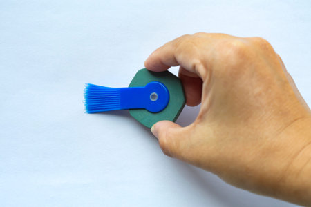 Woman's right hand holding vintage pen round rubber eraser with brush, Close up shot, Stationery...