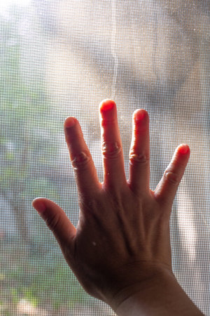 Woman's right hand touching dust Dirty mosquito wire screen window, Light & Shadow shot, Silhouette,...