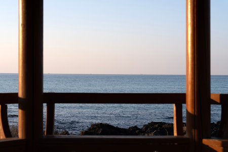 Beautiful view of the sea from the traditional Korean pavilion in Jeju Island, South Koreaの写真素材